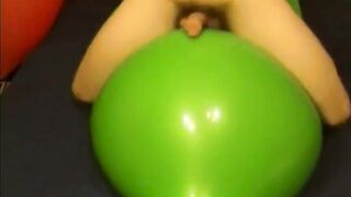 Watch this amateur guy stroke his cock with a big green balloon while cumming hard